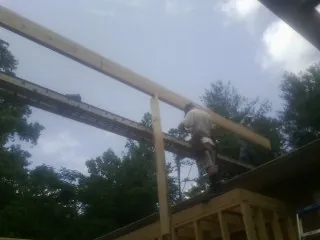 Carpenter setting a ridge beam over a new addition frame — Ice Dam Removal by Roofing Brothers in Purcellville