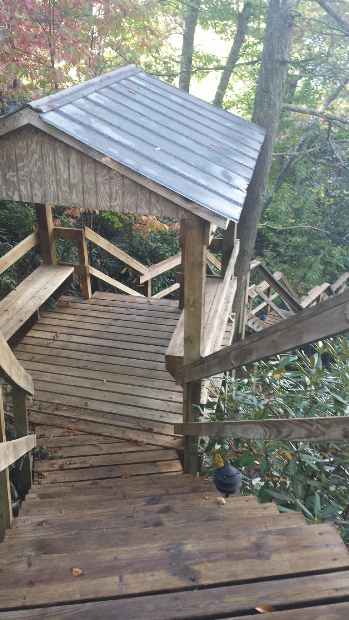 Metal roofed shelter over wooden steps on a wooded walkway — Skylight Repair & Installation work by our crew in Purcellville