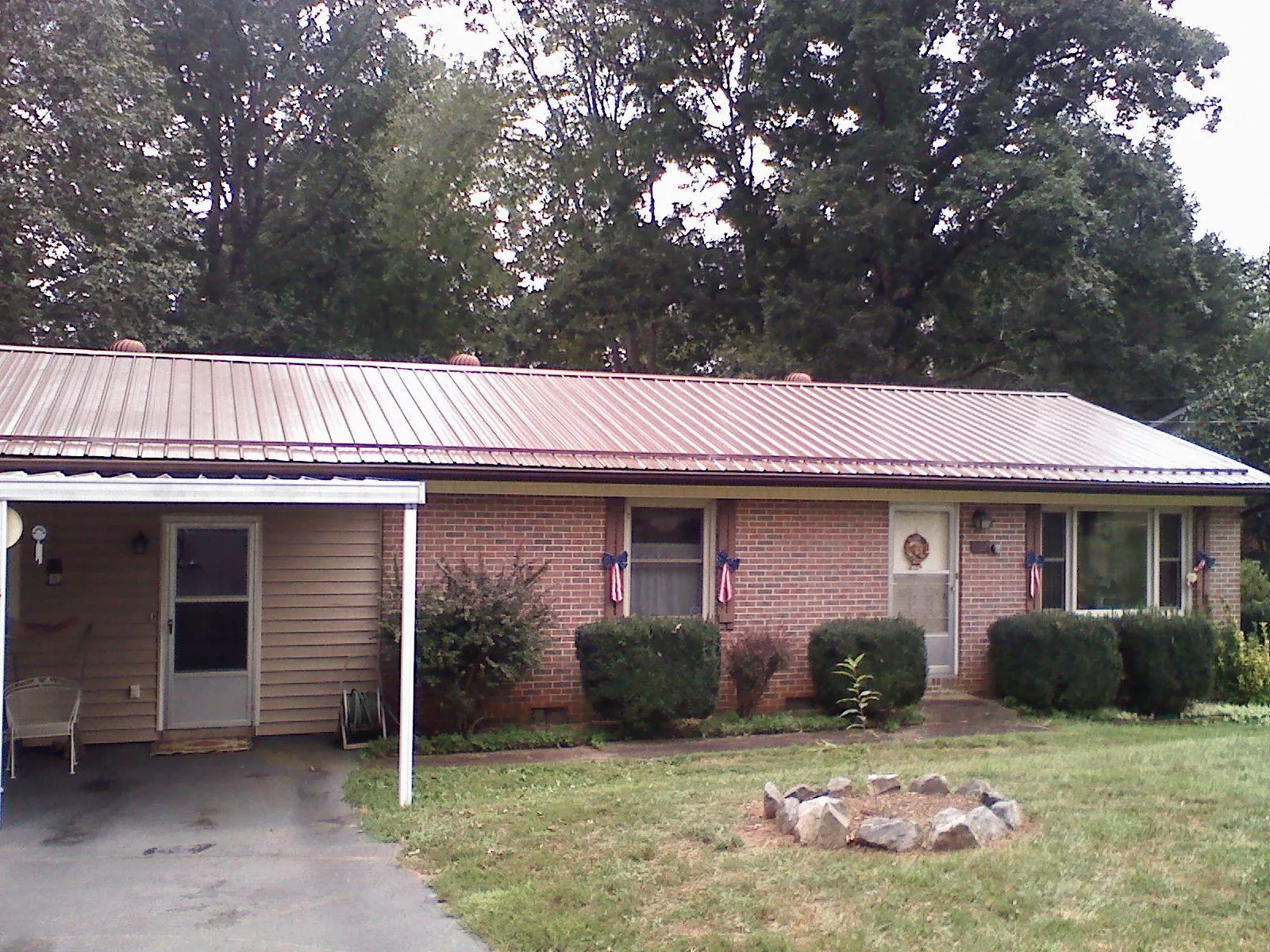 Bronze metal roof and carport on a brick ranch home — Roof Repair work by our crew in Purcellville